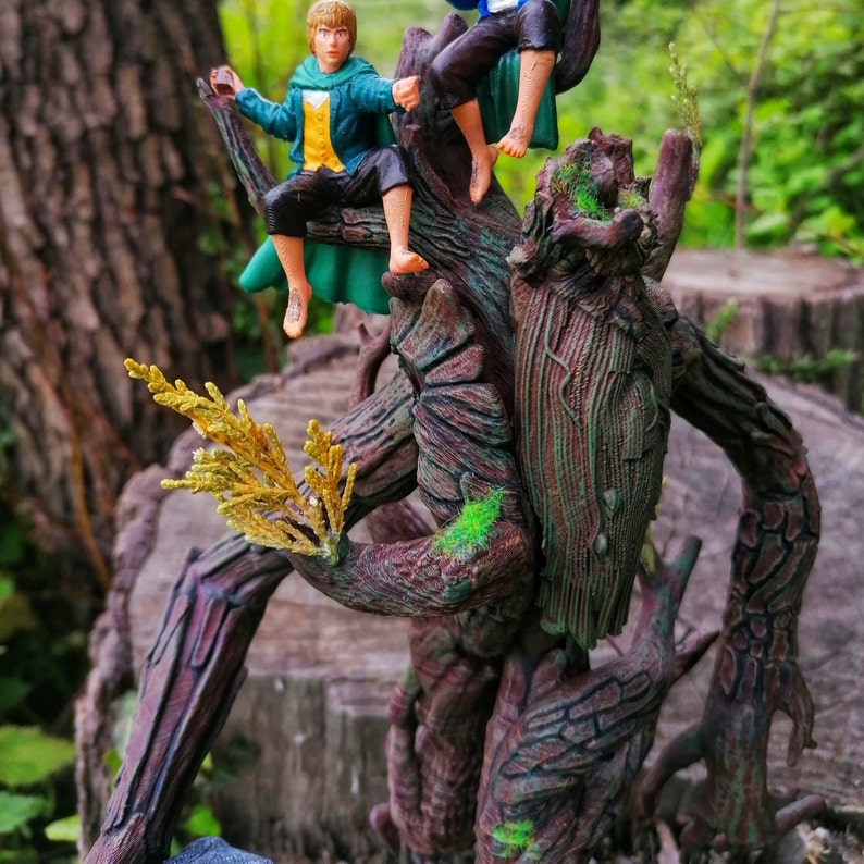 May include: A tree-like figure with a rough, brown bark texture and green moss accents. Two small figures, one in a green and blue outfit and the other in a brown and green outfit, are perched on the tree figure.