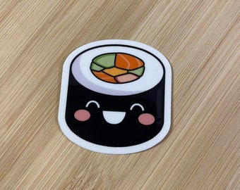 May include: A black and white cartoon sushi roll with a smiling face. The sushi roll has a green, orange, and white filling.