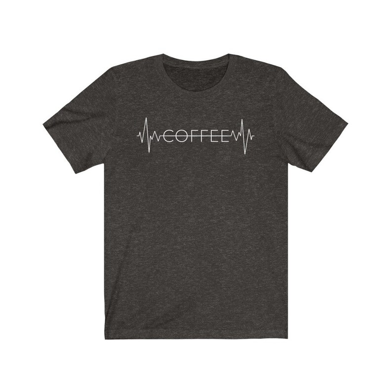 Pode incluir: Uma camiseta cinza escura mesclada com um gr&aacute;fico branco de um batimento card&iacute;aco com a palavra "COFFEE" dentro.