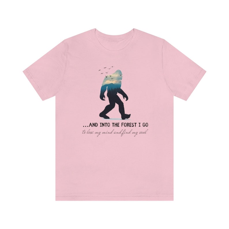 Peut inclure: T-shirt rose avec une silhouette de Bigfoot marchant dans une for&ecirc;t. Le texte dit "...AND INTO THE FOREST I GO to lose my mind and find my soul."