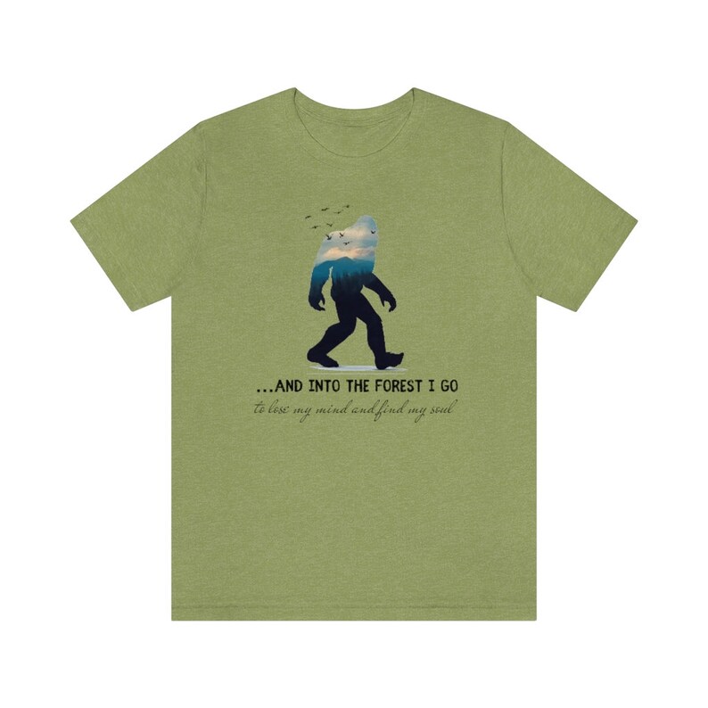 Peut inclure: T-shirt vert avec une silhouette de Bigfoot marchant dans une for&ecirc;t. Le texte dit "...AND INTO THE FOREST I GO to lose my mind and find my soul."