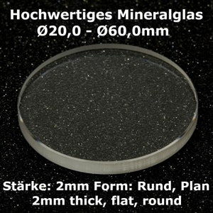 Op de afbeelding: Een rond, helder mineraalglas voor horloges, 2 mm dik, met een diameter van 20 tot 60 millimeter. De tekst "Hochwertiges Mineralglas Ø20,0 - Ø60,0mm Stärke: 2mm Form: Rund, Plan 2mm thick, flat, round" is onder het glas afgedrukt.