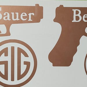 K&ouml;nnte beinhalten: Kupferfarbene Vinylaufkleber mit Pistollensilhouetten und Markennamen. Das Bild zeigt eine Sig Sauer Pistolenkontur mit dem Markennamen dar&uuml;ber und einem kreisf&ouml;rmigen Logo darunter. Eine Beretta Pistolenkontur mit Markennamen und Logo ist ebenfalls abgebildet.