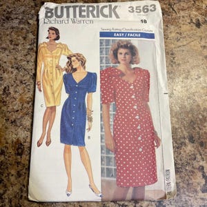 Op de afbeelding: Een Butterick naaipatroon, nummer 3563, met illustraties van jurken met knopen. Het patroon bevat een rode jurk met witte stippen, een blauwe jurk en een gele jurk. De tekst op het patroon luidt "EASY/FACILE".
