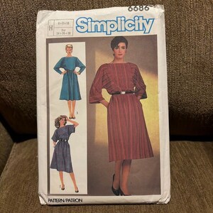 May include: Simplicity sewing pattern number 6686 for a dress. The pattern includes three different styles of dresses, all with a boat neck and three-quarter sleeves. The pattern is for sizes 6-8-10 and European sizes 34-36-38.