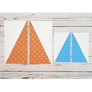 May include: Two fabric triangles, one orange with a white pattern and one blue with a white pattern, are laid out on a white wooden surface.