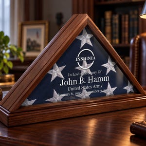 May include: A triangular wooden display case containing a folded flag with white stars on a blue background. The glass front features the text INSIGNIA, In Loving Memory Of, John B. Hamm, United States Army, January 6, 1995 - December 3, 2023.