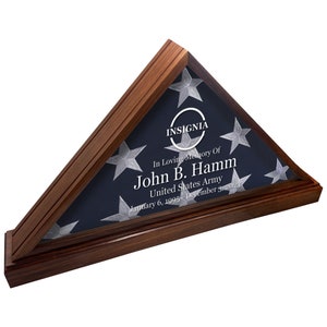 Könnte beinhalten: Ein hölzerner Flaggen-Präsentationskasten mit einer gefalteten amerikanischen Flagge im Inneren. Der Kasten hat eine Plakette mit der Inschrift "INSIGNIA" und dem Text "In Loving Memory Of John B. Hamm United States Army January 6, 1995 December 31, 2023".