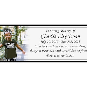Pode incluir: Uma fotografia a preto e branco de uma menina a p&eacute; numa passarela de madeira. A menina est&aacute; a usar uma camisa preta com as palavras "Future Leader" impressas nela. O texto "In Loving Memory Of Charlie Lily Doan July 20, 2015 - March 5, 2023 Your time with us may have been short, but your memories with us will live on forever. Forever in our hearts." est&aacute; impresso abaixo da fotografia.