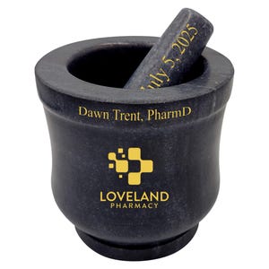 May include: A dark gray mortar and pestle with gold lettering. The mortar has the text "Dawn Trent, PharmD" and "LOVELAND PHARMACY". The pestle has the text "July 5, 2025".