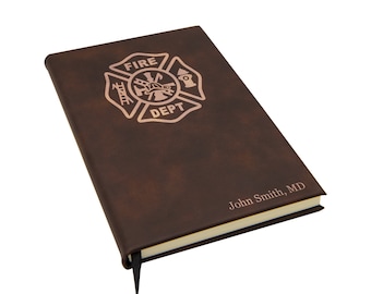 Op de afbeelding: Een bruin lederen gebonden dagboek met een goudkleurig reliëf van een brandweerlogo en de tekst "FIRE DEPT" en een gepersonaliseerde inscriptie "John Smith, MD".
