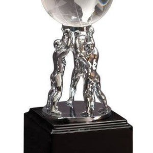 May include: A silver trophy with a clear glass globe supported by three silver figures. The base is glossy black with a stepped design. A decorative award.