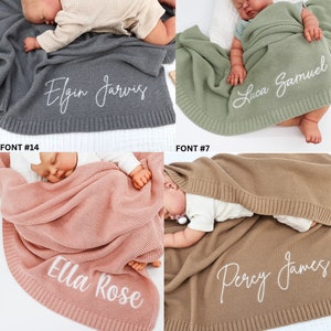May include: Four baby blankets in different colors: gray, sage green, dusty rose, and tan. Each blanket has a knitted texture and a personalized name embroidered in white script. The names are Elgin Jarvis, Luca Samuel, Ella Rose, and Percy James.