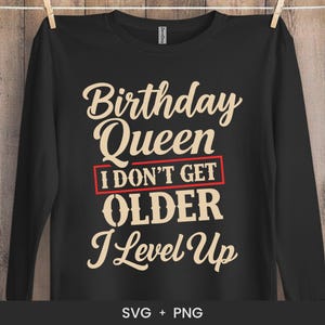 Puede incluir: Camiseta negra de manga larga con el texto "Birthday Queen I Don't Get Older I Level Up" en color crema. El texto "I Don't Get" está en un rectángulo rojo. La parte inferior de la camiseta tiene el texto "SVG + PNG".