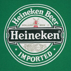 May include: A green background featuring the Heineken Beer logo. The circular logo has the word "Heineken" in white, a red windmill, and the word "IMPORTED" at the base. The text "HOLLAND BEER" is also visible.