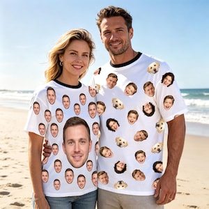 May include: Two white short-sleeved t-shirts with black crew neck collars, each featuring a repeating pattern of various human faces and golden retriever dog faces printed across the fabric, with one shirt highlighting a large central face print.