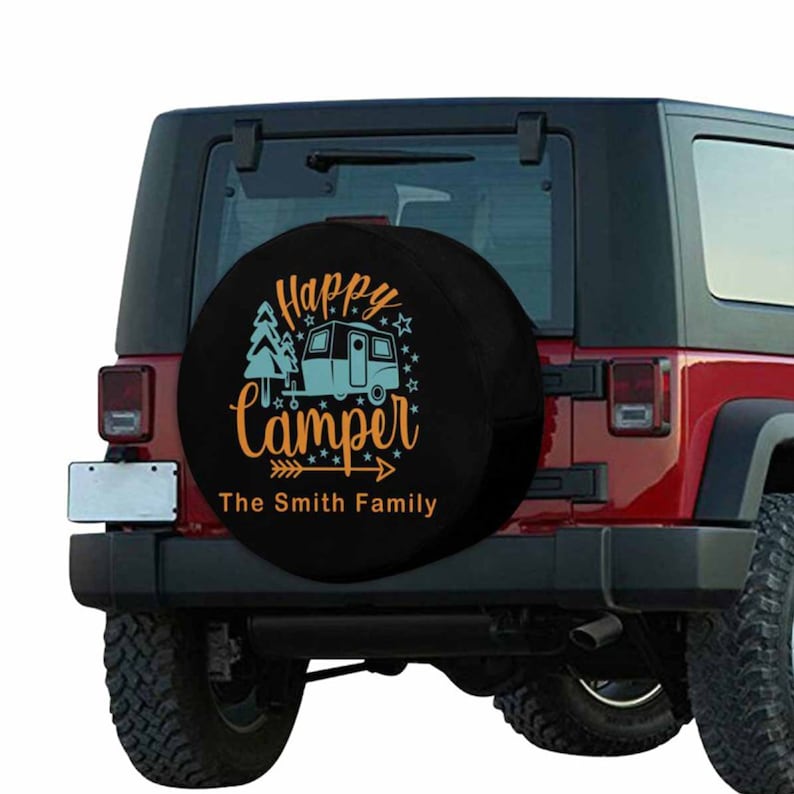 May include: Black spare tire cover with a white camper and trees, orange text that says "Happy Camper" and "The Smith Family" on a red Jeep.