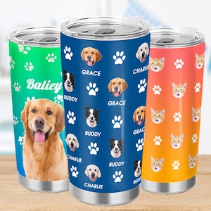 May include: Three stainless steel tumblers with pet-themed designs. One is green with a Golden Retriever and the name "Baliey". The second is blue with dog faces, paw prints, and names. The third is orange with cat faces and paw prints.