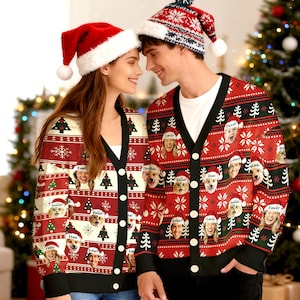 May include: Two people wearing matching red Christmas cardigans with custom faces and names, along with Santa hats. The cardigans feature Christmas trees, snowflakes, and black trim. A festive holiday theme.