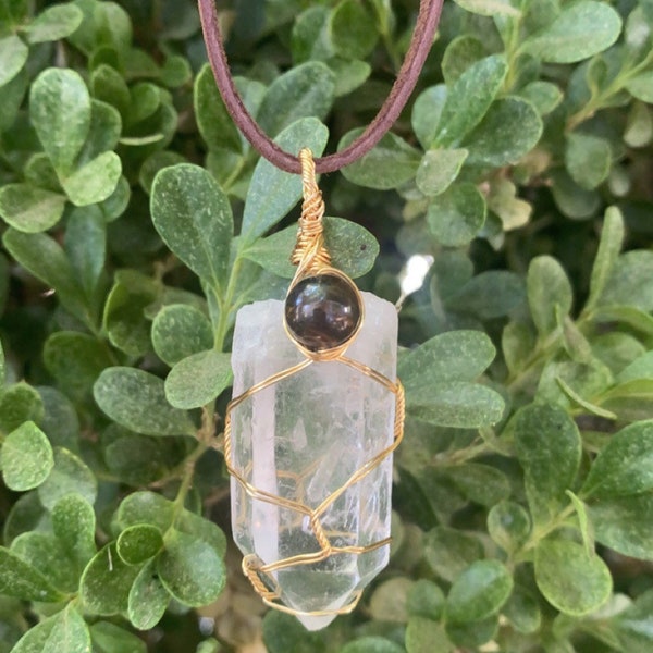 Quartz de haute qualité avec perle d’œil de tigre et cordon de toile de jute.