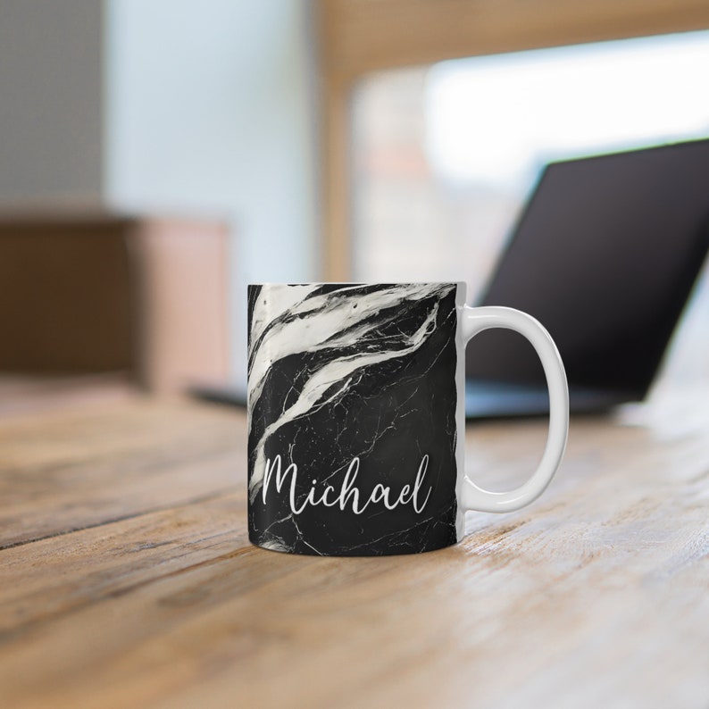 May include: White ceramic mug with a black and white marble design. The mug has a white handle and the name "Michael" is written in white on the front.