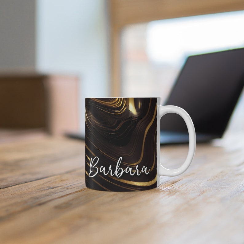 May include: White ceramic mug with a black and gold marbled design. The mug has the name "Barbara" written in white on the front.
