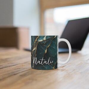 May include: White ceramic mug with a green and gold marble pattern and the name "Natalie" written in white script.