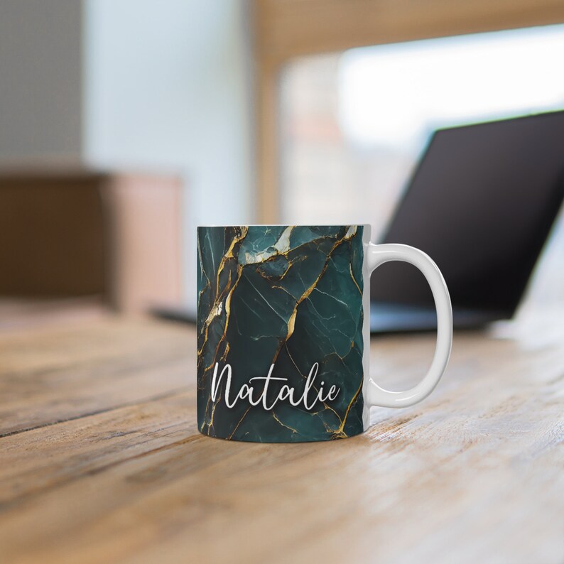 May include: White ceramic mug with a green and gold marble pattern and the name "Natalie" written in white script.