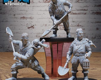 May include: Three gray miniature figures of a fantasy character with shovels, lanterns, and skull accents. The figures are posed in action, with one figure holding a shovel, another carrying a skull, and the third holding a lantern. The text "EPIC Miniatures" is in the upper left corner.