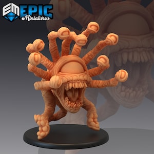 Puede incluir: Una figurita miniatura de color beige de una criatura con un solo ojo grande, una boca abierta con dientes y múltiples tentáculos. La criatura está de pie sobre una base negra.