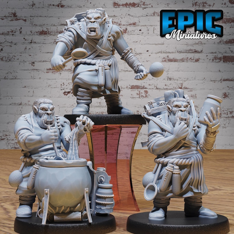 May include: Three grey painted miniature figurines of orcs, each holding a different cooking utensil. The orcs are wearing clothing and have detailed facial features. The text "EPIC Miniatures" is visible in the background.