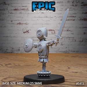 May include: A gray miniature figure of a robot warrior holding a sword and shield. The figure has a circular head and body details. The base size is medium (25.5mm). The Epic Miniatures logo is at the top.
