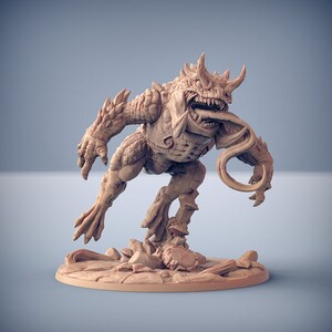 Peut inclure: Une figurine miniature détaillée d'une créature monstrueuse reptilienne avec une longue langue enroulée. La créature a un corps épineux et blindé et est posée dans une posture dynamique de saut.