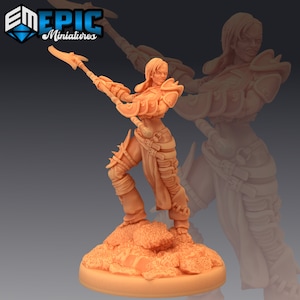 May include: A detailed miniature figurine of a female warrior in a pose of attack, holding a spear in her right hand. She is wearing armor and a skirt, and her expression is fierce. The figurine is painted in a light brown color and is standing on a rocky base.