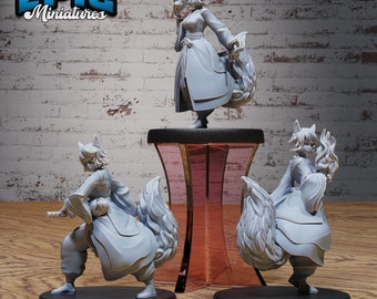 May include: Three grey painted figurines of a fox-like creature with a long, bushy tail. The figurines are posed in different stances, one holding a mask, one with a sword, and one with a hand on its hip. The figurines are on a wooden surface with a brick wall in the background.