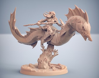 May include: A miniature figurine of a female elf riding a sea serpent, both painted in a light brown color. The elf is holding a spear and the serpent has a large, open mouth. The figurine is set on a base with a coral reef design.