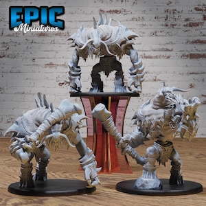 Puede incluir: Tres figuras en miniatura grises y detalladas de criaturas fantásticas. Las figuras están en diferentes posturas y parecen estar hechas de un material plástico duro. Las figuras están sobre una superficie de madera con una pared de ladrillo en el fondo.