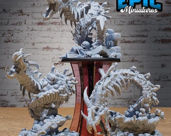 May include: Three detailed skeletal dragon miniatures, each with a different pose, are displayed on a wooden base. The dragons are made of a light gray plastic and have a textured surface. The base is painted a dark red color. The text "EPIC Miniatures" is visible in the upper right corner of the image.