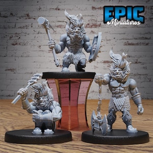 May include: Three gray painted miniature figurines of a creature with a fiery mane, each holding a different weapon. The creature on the left holds a spear, the middle creature holds a hammer, and the creature on the right holds an axe. The miniatures are on black bases and are displayed on a wooden surface.