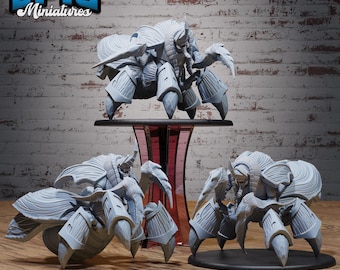 May include: Three gray miniature crab-like creatures with multiple legs and armored exoskeletons. One is elevated on a black stand, and the other two are on a wooden surface. The logo "EPIC Miniatures" is in the upper left corner.