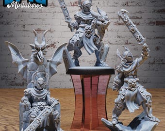 May include: Three grey resin miniature figures featuring armored warriors with horned helmets and ornate swords. One figure sits on a stone throne with a dragon-like backrest, while two others stand in dynamic poses on circular bases.