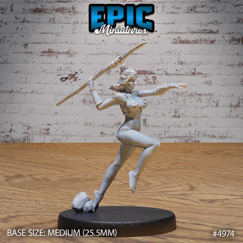May include: A gray unpainted miniature figurine of a woman holding a spear, standing on a black base with a small rock formation. The base is labeled "BASE SIZE: MEDIUM (25.5MM)" and "#4974".