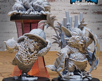 May include: Three gray 3D printed miniature figurines. The first is a sleeping furry creature with large ears. The second is a furry creature with large ears and a small loincloth. The third is a dwarf-like creature with a helmet and a chainmail shirt. The figurines are on circular bases.