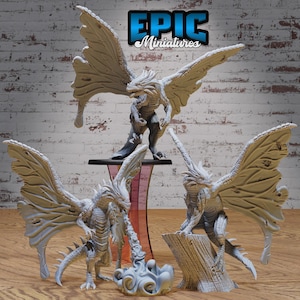 May include: Three white painted dragon miniatures with wings outstretched. The dragons are posed in different positions, with one dragon blowing a stream of smoke. The miniatures are on a wooden surface with a brick wall in the background. The text "EPIC Miniatures" is visible in the top center of the image.