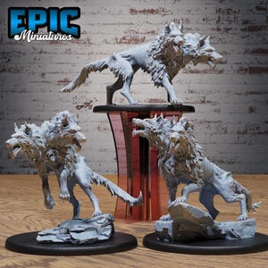 May include: Epic Miniatures presents three detailed, gray wolf figurines. One stands atop a pedestal, while the others are posed on rocky bases. The wolves have a fierce, skeletal appearance, with detailed fur and open mouths, perfect for tabletop gaming.