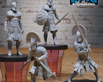 May include: Four grey plastic miniature figures of Greek warriors wearing helmets and armor, holding swords and shields. The figures are posed in various action stances. The figures are on a white background with the text "EPIC Miniatures" in black and white.