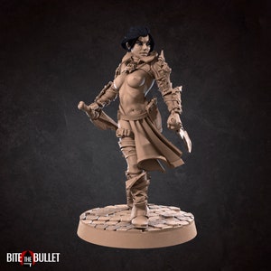 Puede incluir: Una figura en miniatura detallada de una guerrera con armadura y empuñando una espada. La figura está pintada en color marrón claro y está de pie sobre una base circular.