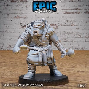 May include: A grey plastic miniature of an Orc wearing a robe and carrying a backpack, a bowl, and a ball. The miniature is standing on a black base. BASE SIZE: MEDIUM (25.5MM) #4967