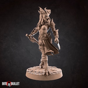 Puede incluir: Una figura en miniatura detallada de una guerrera con cuernos, que lleva armadura y sostiene una daga. La figura está pintada en color marrón claro y se encuentra sobre una base circular.