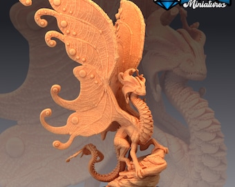 May include: A detailed miniature of a dragon with butterfly wings. The dragon is standing on a rock base and has a textured, scaly body. The wings are large and intricate, with a pattern of circles and veins.